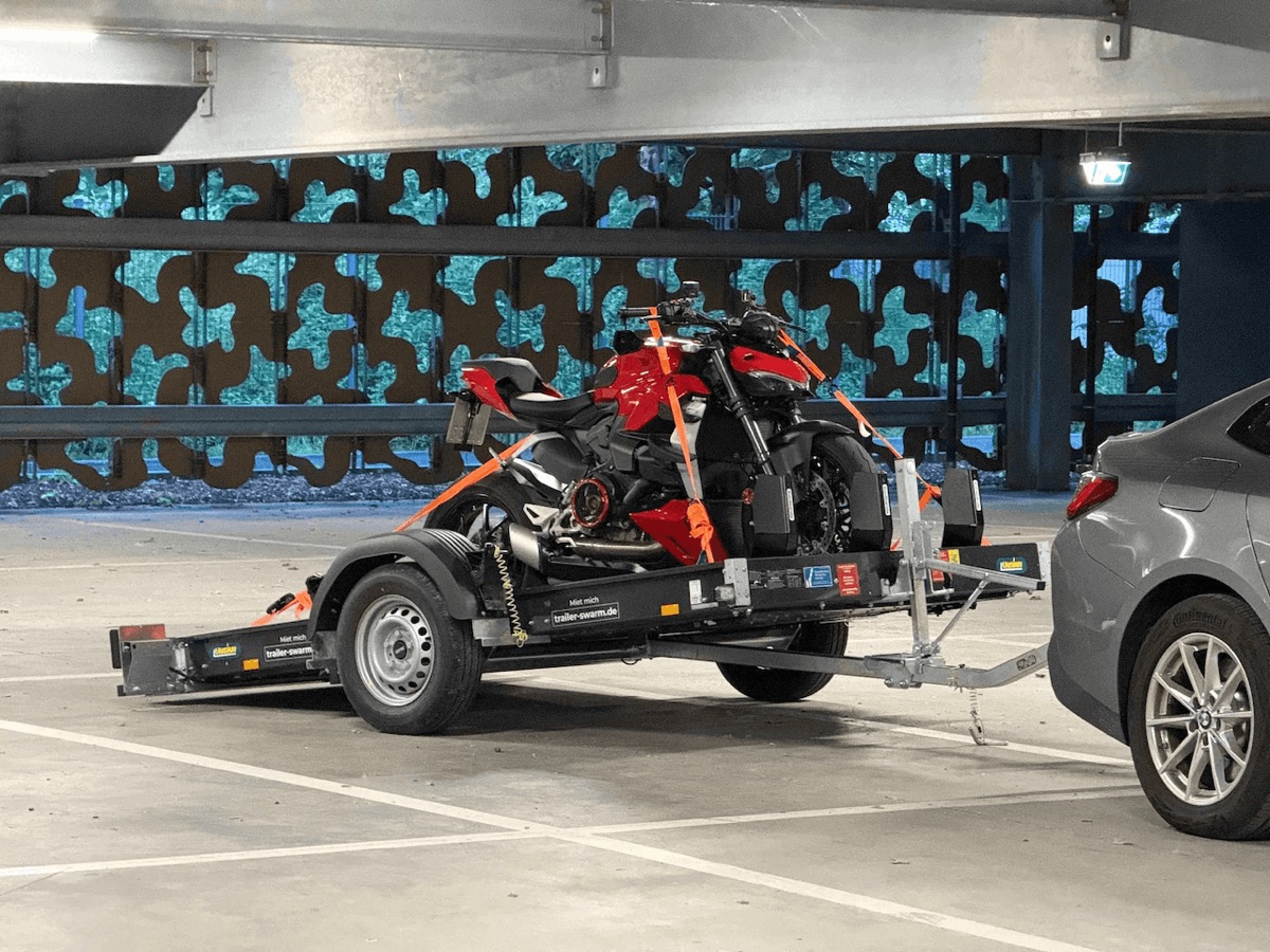 Ducati Streetfighter V2 festgezurrt auf einem fahrbereiten Unsinn-Anhänger von Trailer Swarm, an ein Auto gekuppelt in einer Tiefgarage