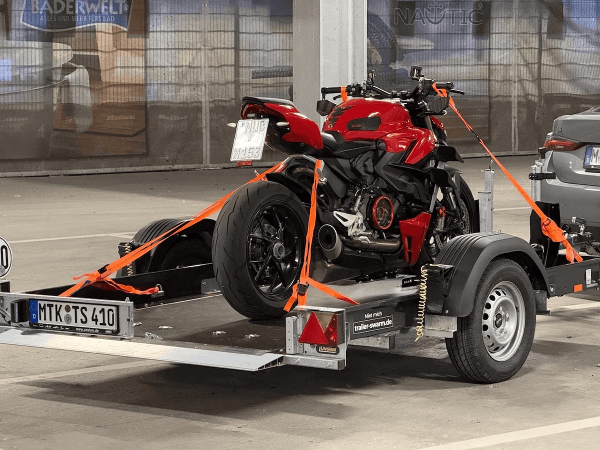 Ducati Streetfighter in der Motorradwippe auf dem noch abgekippten Unsinn-Anhänger, mit orangen Spanngurten verzurrt